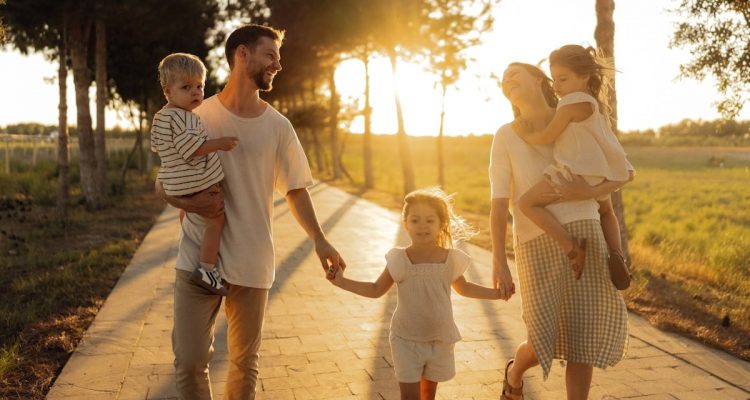 Family walking on path with trees at sunset